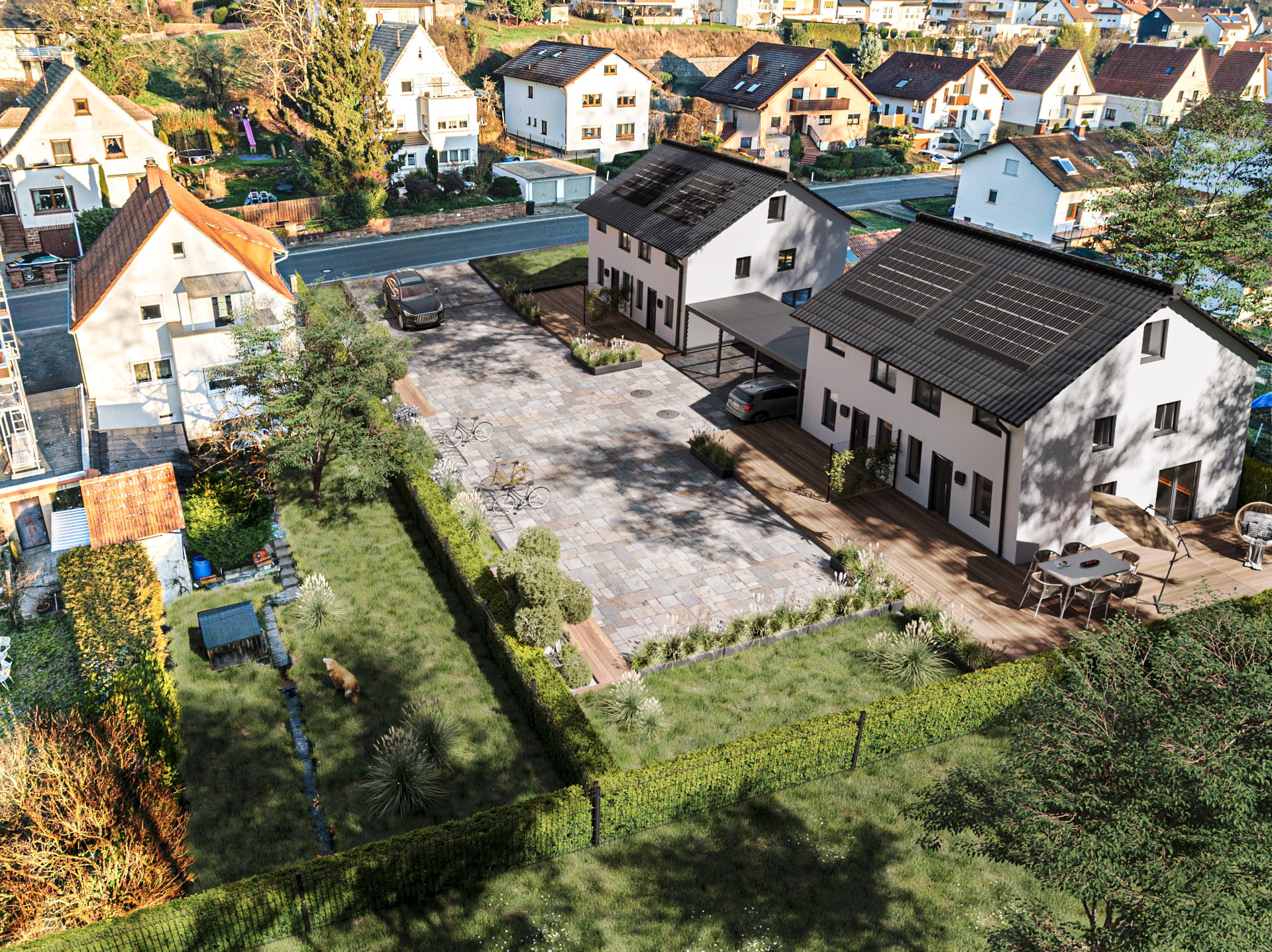 Eine fotorealistische Drohnenaufnahme zeigt das modernisierte Wohngrundstück. Zentral stehen zwei neue, modern gestaltete Doppelhaushälften mit hellgrauer Fassade, dunklen Dächern und Solaranlagen (Photovoltaik).